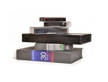 Stack of various vintage videotapes.