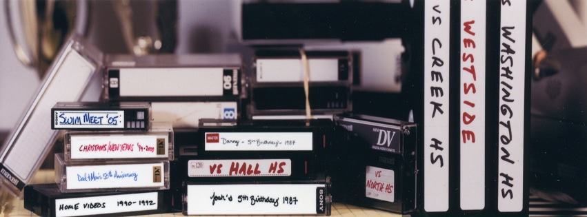 Collection of labeled VHS tapes on a desk.